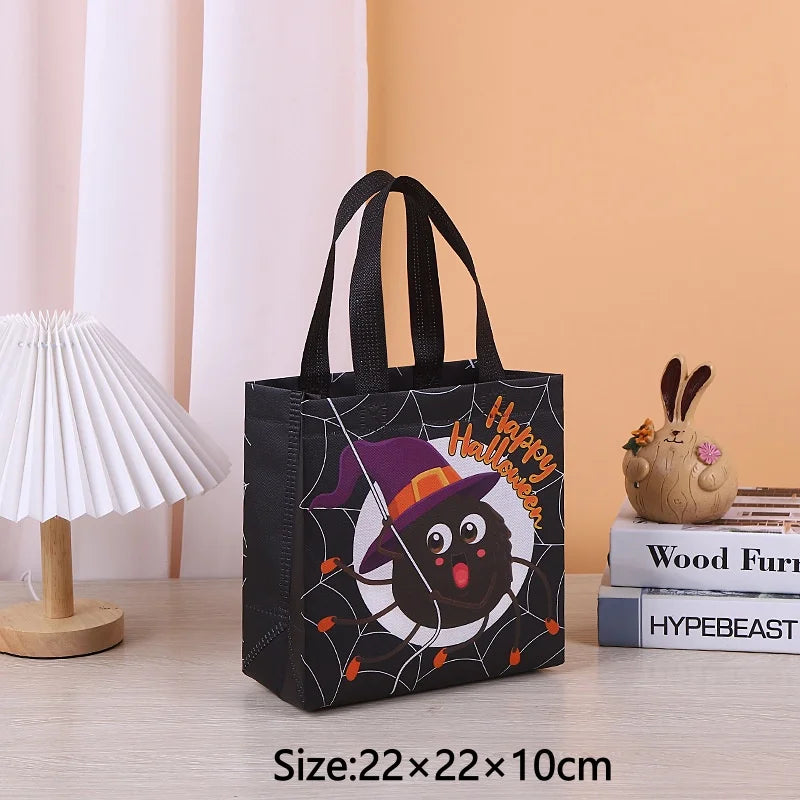 Black non-woven tote bag with a happy Halloween print featuring a bat and spider on a light orange background.