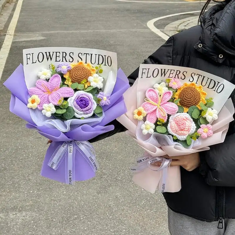 A bouquet of handmade crochet flowers in purple and pink hues is held by a person.