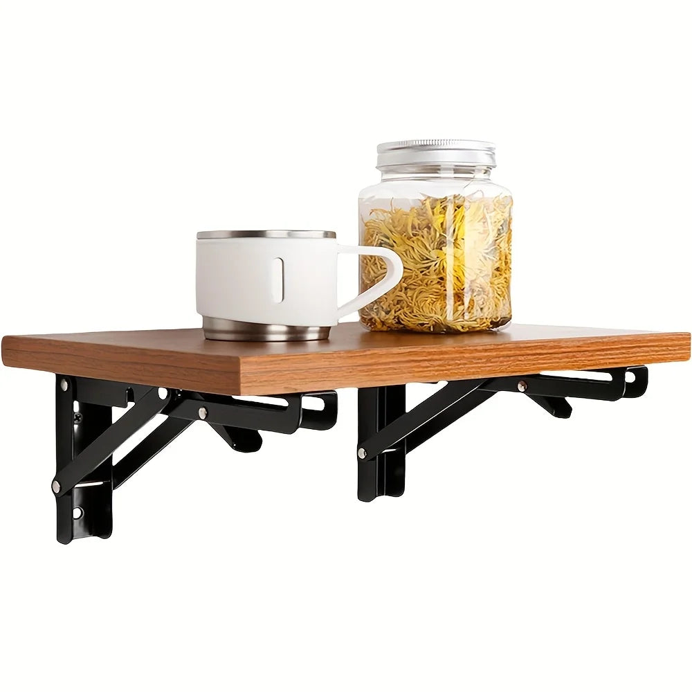 A set of two heavy-duty foldable wall-mounted shelf brackets supporting a wooden shelf.