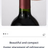 A hand is holding a dark glass bottle with a silicone stopper, showing the product's design.