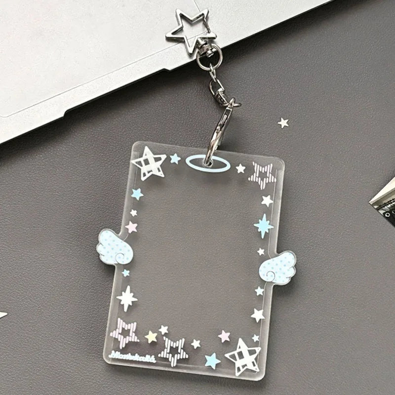 Clear acrylic photocard holder with star and cloud designs attached to a silver keychain.