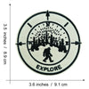 Black embroidered patch with the word EXPLORE inside a circular design featuring silhouettes of trees and a Bigfoot figure.
