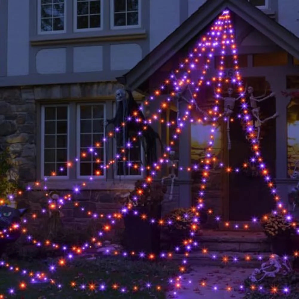 Purple Halloween spider web lights draped across a porch and garden area.