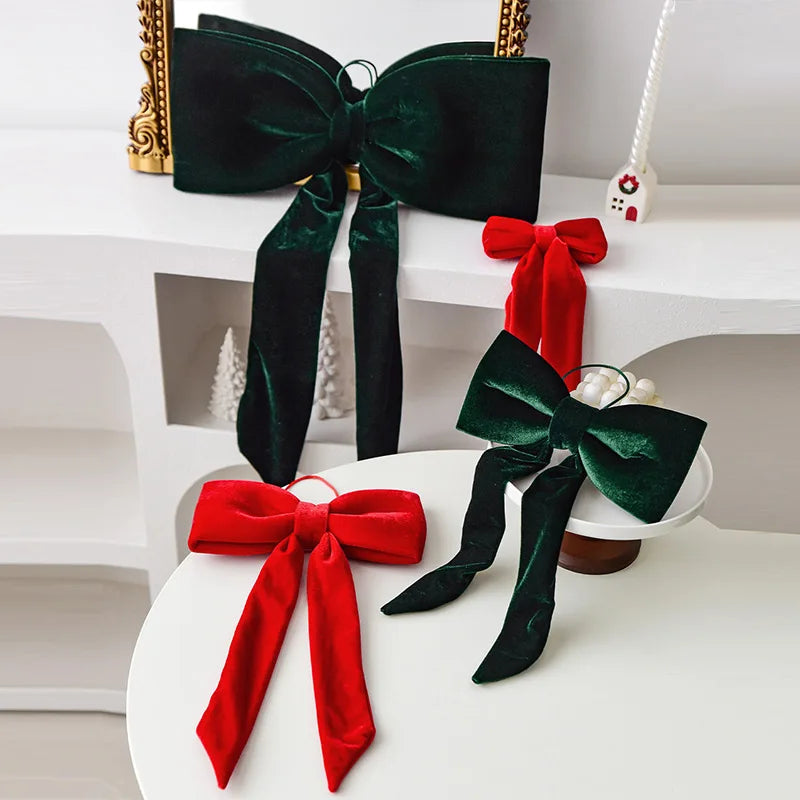 A set of twelve velvet Christmas tree bows in red and green colors displayed on a white surface.