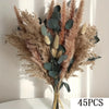 A bouquet of dried pampas grass and eucalyptus leaves in natural beige and dusty rose tones.