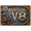 A vintage retro metal wall sign featuring the text NEVER LATE IN and the number V8, with aged bronze and dark blue patina.
