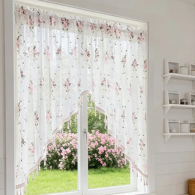 Elegantes Dreieck-Spitzenvorhang mit rosa Blumenmuster, der eine Glastür oder -fenster bedeckt.