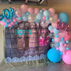 Pink and blue foil letter balloons spelling BOY or GIRL for a gender reveal party display