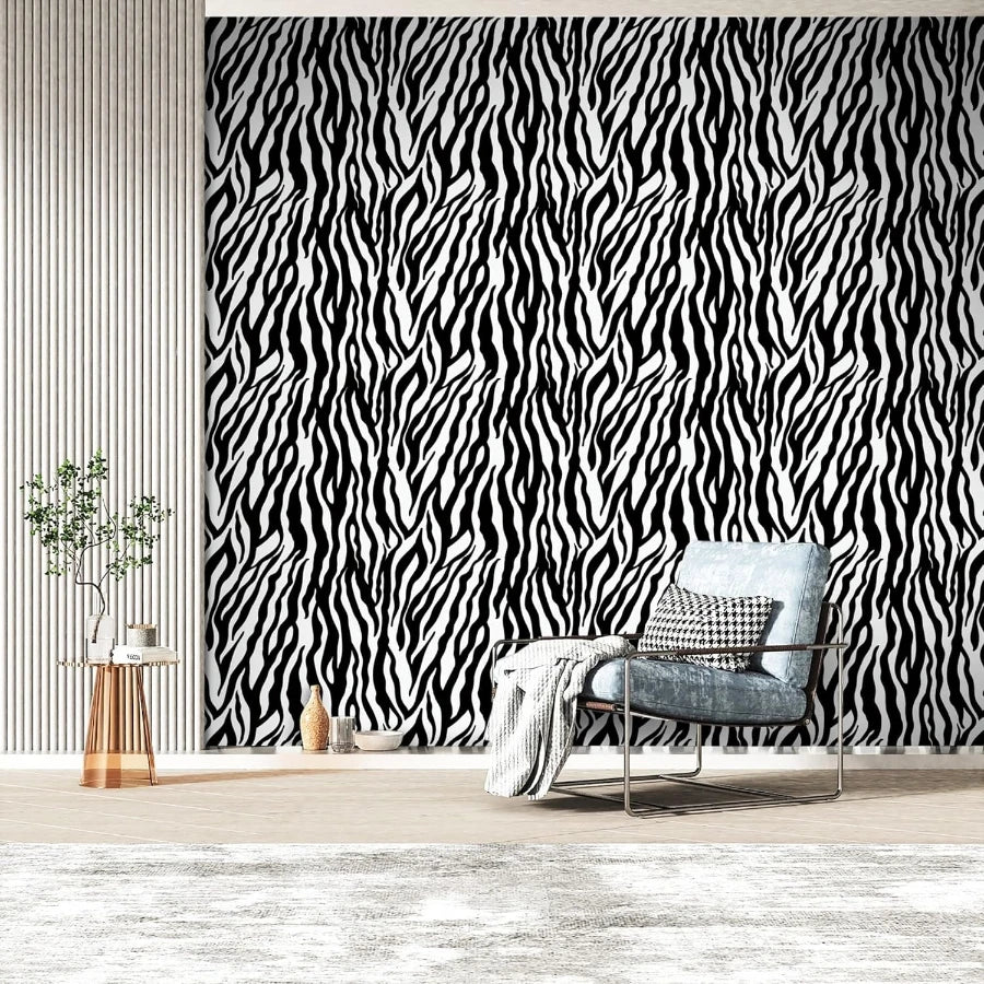 A modern interior featuring a black and white zebra print wall, a gray armchair, and a potted plant.