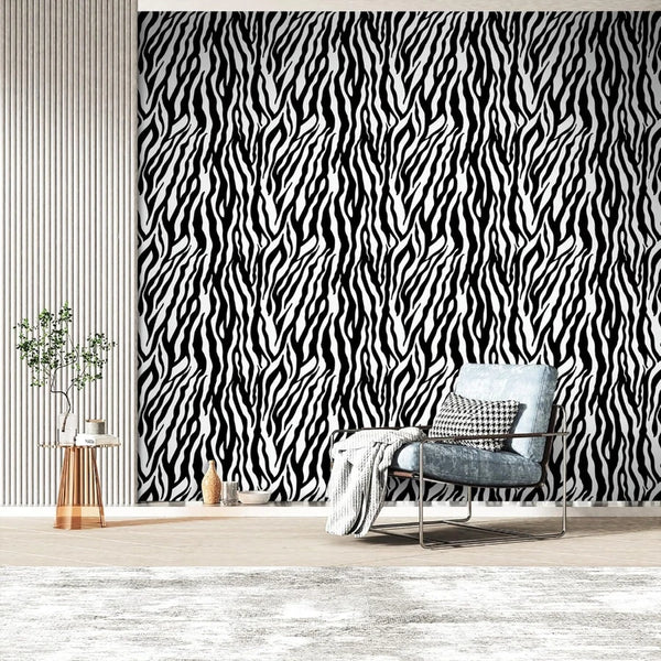 A modern interior featuring a black and white zebra print wall, a gray armchair, and a potted plant.