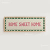 A framed canvas print with the text HOME SWEET HOME in pink lettering on a cream background with a green border.