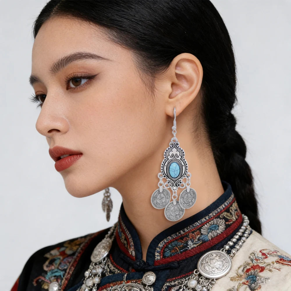 Gros plan d'une femme portant des boucles d'oreilles en pièces de monnaie turquoise bohèmes avec une tenue traditionnelle