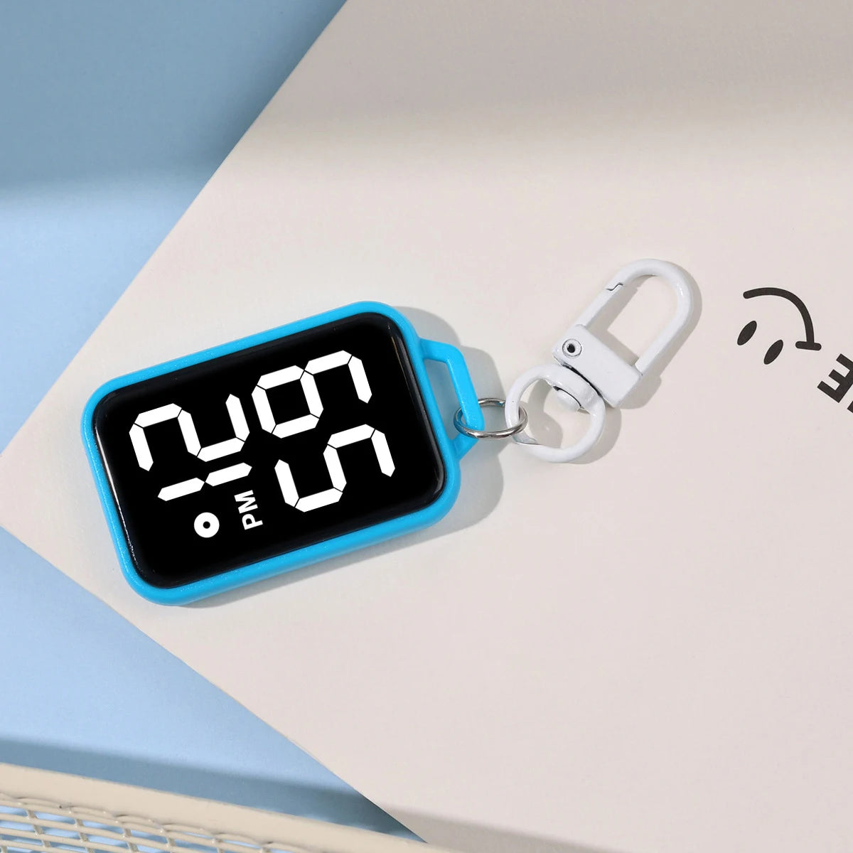 A blue LED keychain pocket watch with a digital display showing 12:00 PM.