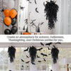 A display of artificial eucalyptus leaf faux plants used for home decor, featuring black and orange Halloween and holiday dec