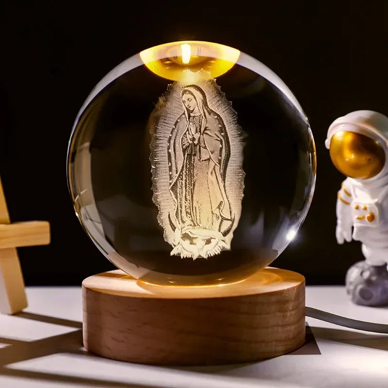 A glass crystal ball night light with a glowing candle inside, resting on a wooden base.