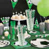 A collection of soccer party supplies including balloons, green and white decorations, cupcakes, and soccer balls.