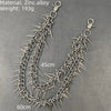 A silver zinc alloy necklace featuring numerous sharp rivets and spikes, displayed against a gray background.