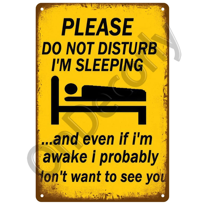 A yellow vintage metal sign with black text warning people not to disturb while sleeping.