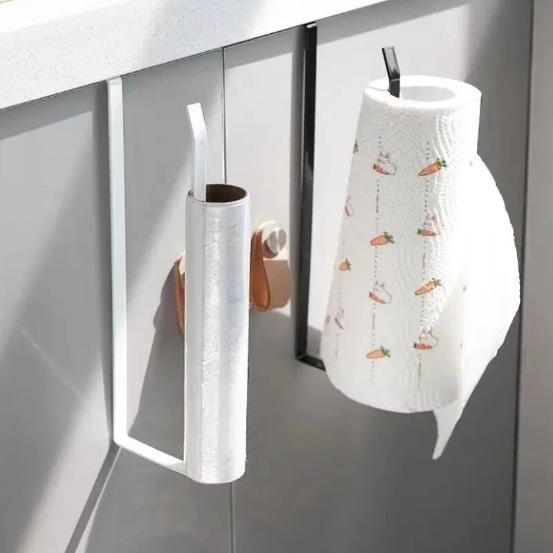 White paper roll holder with a decorative pattern hanging on a kitchen cabinet