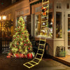 A glowing yellow ladder of Christmas lights resembling Santa Claus climbing down a storefront.