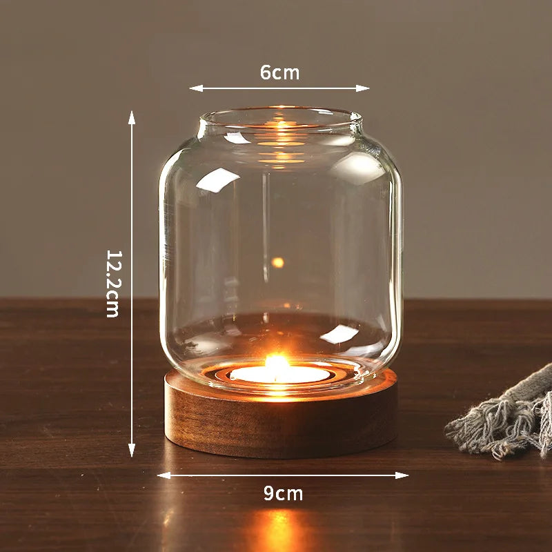 A vintage wooden candle lantern with a glass cover is lit on a dark wooden surface.