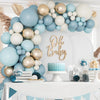 A blue and gold balloon garland arch featuring various sized balloons decorating a white wall for a baby shower or party.