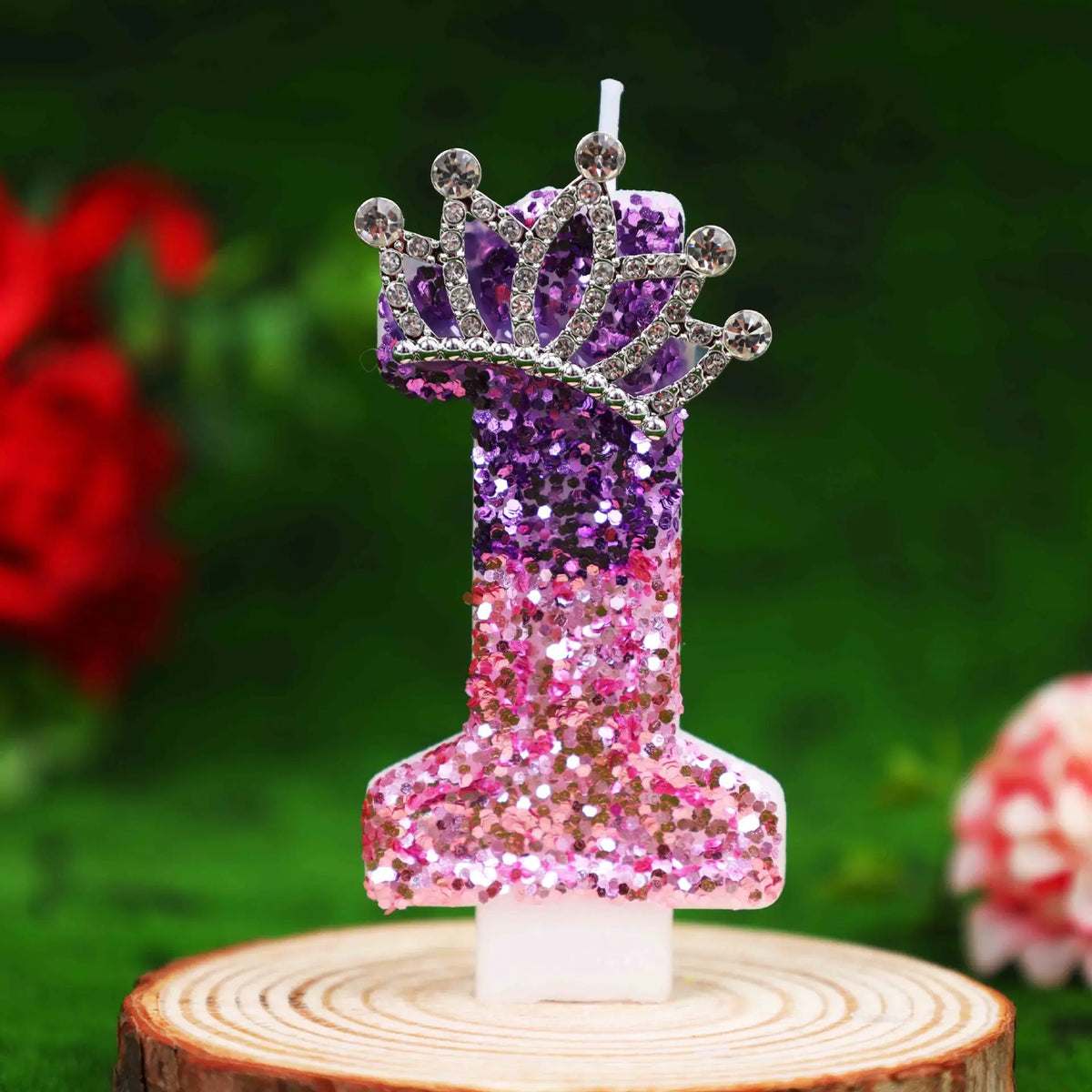 Glitter number birthday candle with a rhinestone crown cake topper featuring purple and pink glitter.