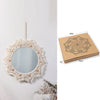 Boho macrame round wall mirror with a distressed white fringe hanging on a white wall.