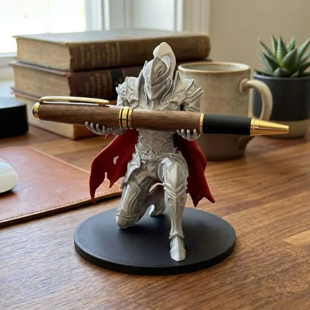A 3D printed knight figurine holding a pen, displayed on a dark circular base next to books and a mug.