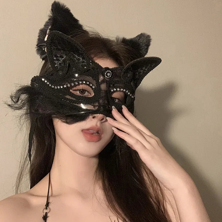 A woman wearing an elegant black lace half-face mask with feathery ears and sparkling details.