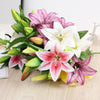 A bouquet of realistic silk lily flowers in shades of pink, white, and purple with green leaves.