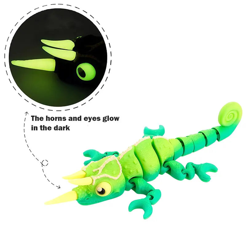 A bright green chameleon fidget toy with glowing yellow horns and eyes against a dark background.