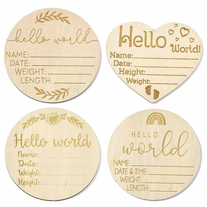Four natural wood baby milestone discs with handwritten text for newborn photography