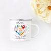 A white enamel mug with a design that reads Teaching is a work of heart and features colorful letters and a heart.