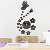 A modern acrylic wall clock featuring a black butterfly and floral design on a white background.
