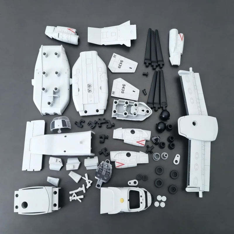 A collection of white V-22 Osprey tiltrotor building blocks and components scattered on a dark gray surface.