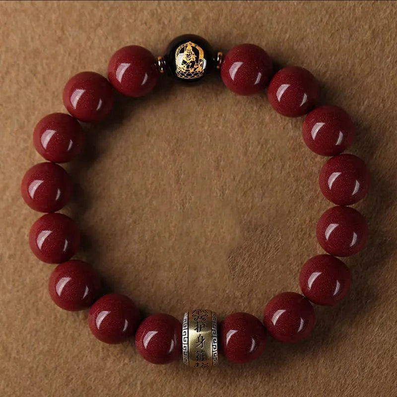 A bracelet made of polished red cinnabar stones and a gold-colored bead on a leather strap.