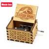A carved wooden Jurassic Park music box with an open lid showing a small metal mechanism inside.