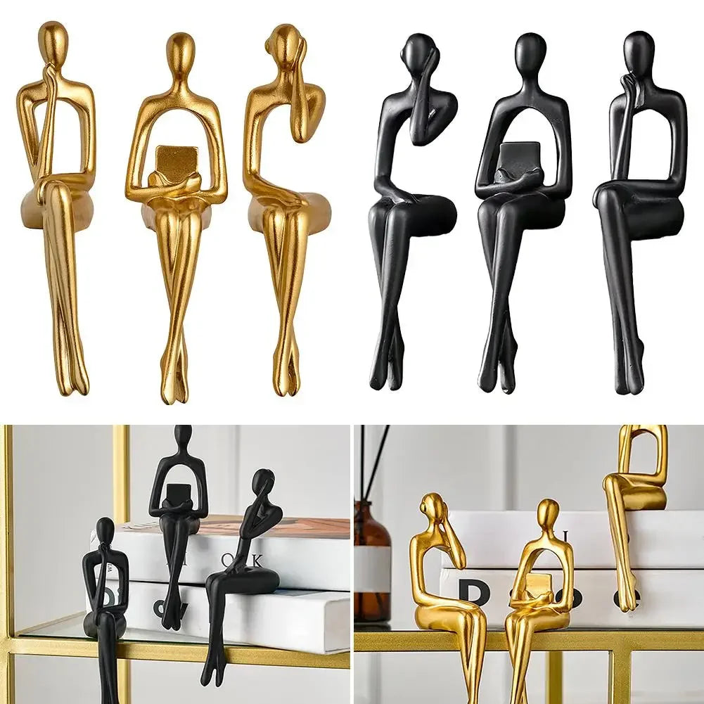 A set of abstract thinker sculptures in gold and black resin, displayed against a white background.