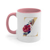 A pink ceramic coffee mug featuring a gold letter Z design with floral accents.