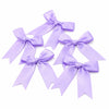 A collection of purple satin ribbon bows tied in various decorative styles.