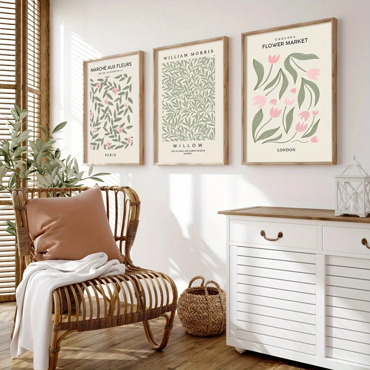 Three framed botanical prints featuring floral designs in muted greens and pinks displayed on a white shelf.