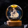A clear crystal ball with a golden glow features an engraving of a person sitting in the style of Aquarius.