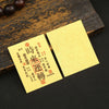 A yellow sticker with red Chinese characters for lucky wealth and prosperity is placed on a dark wooden surface.