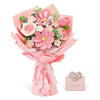 A bouquet of handcrafted crochet tulip flowers in various shades of pink and green, wrapped in pink paper.