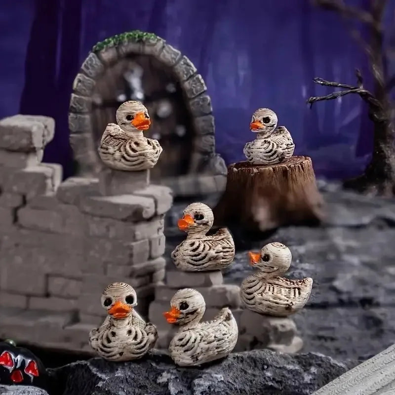 A collection of resin skull duck figurines displayed on a dark, rocky surface with a stone archway background.
