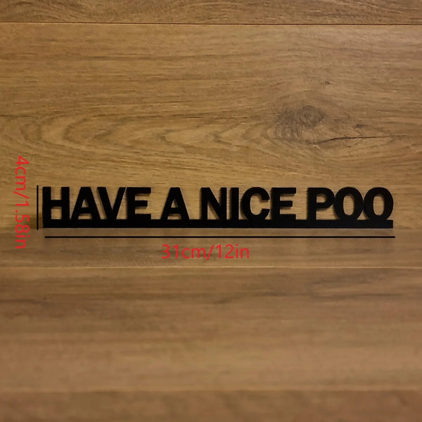 A black acrylic sign with the text HAVE A NICE POO is mounted on a wooden surface.