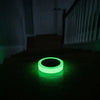 Un ruban circulaire vert lumineux est placé sur une surface en bois foncé.
