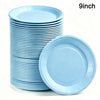 A stack of light blue disposable paper plates with a single plate lying next to the stack.