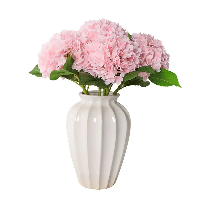 Pink hydrangea flowers in a white vase
